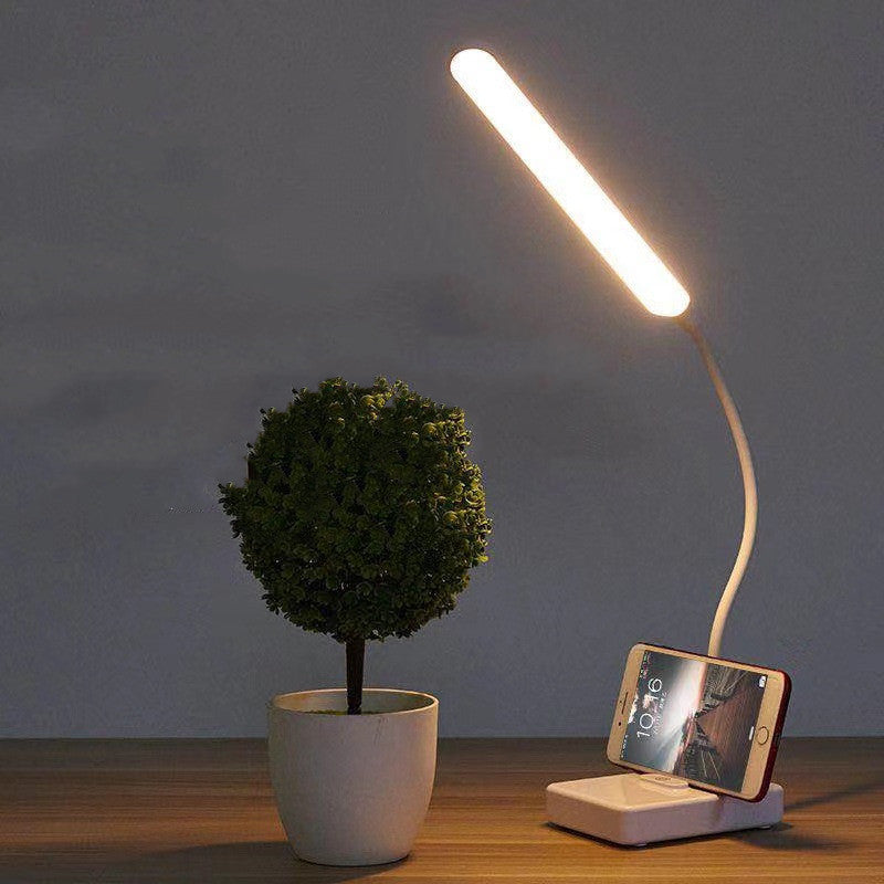 LED desk lamp with phone stand slot
