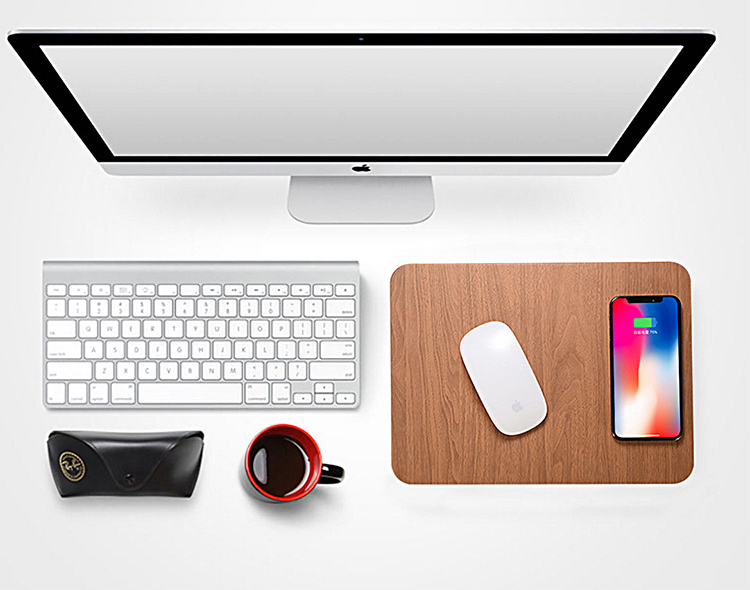 Wood-grain wireless charging mouse pad on a desk with keyboard and phone