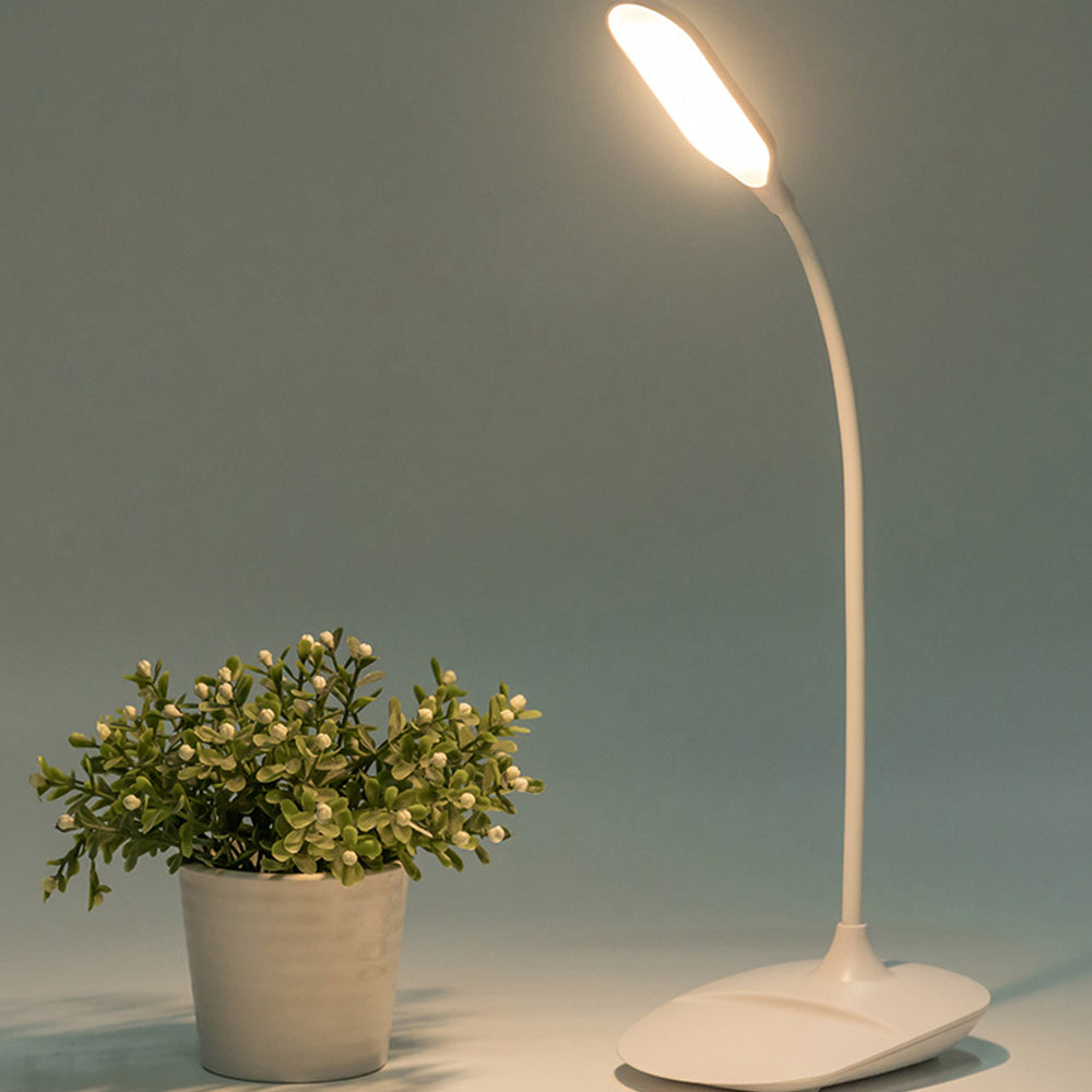 Eye-care desk lamp lit over a notebook