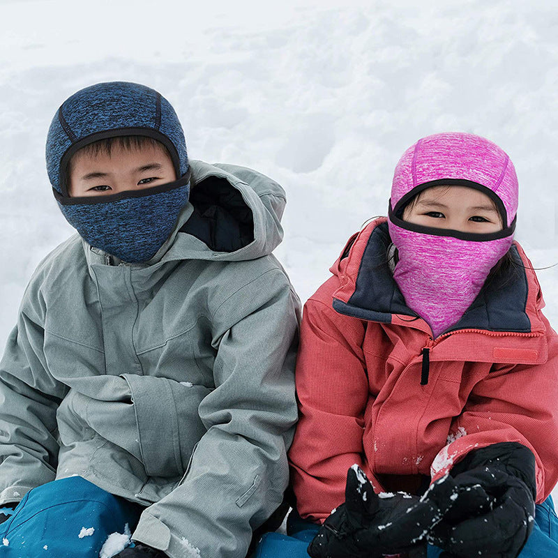 Two children in snow wearing navy and pink balaclava hoods