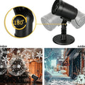 Outdoor snowflake LED projection lamp lighting a house wall at night