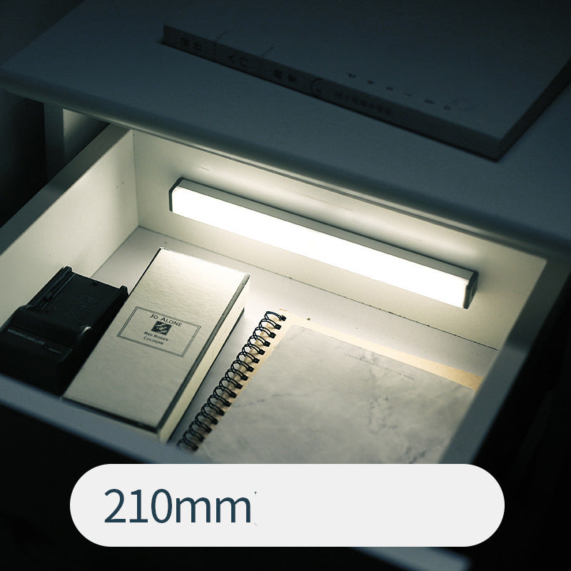 Under-cabinet LED sensor light bar glowing under a kitchen shelf