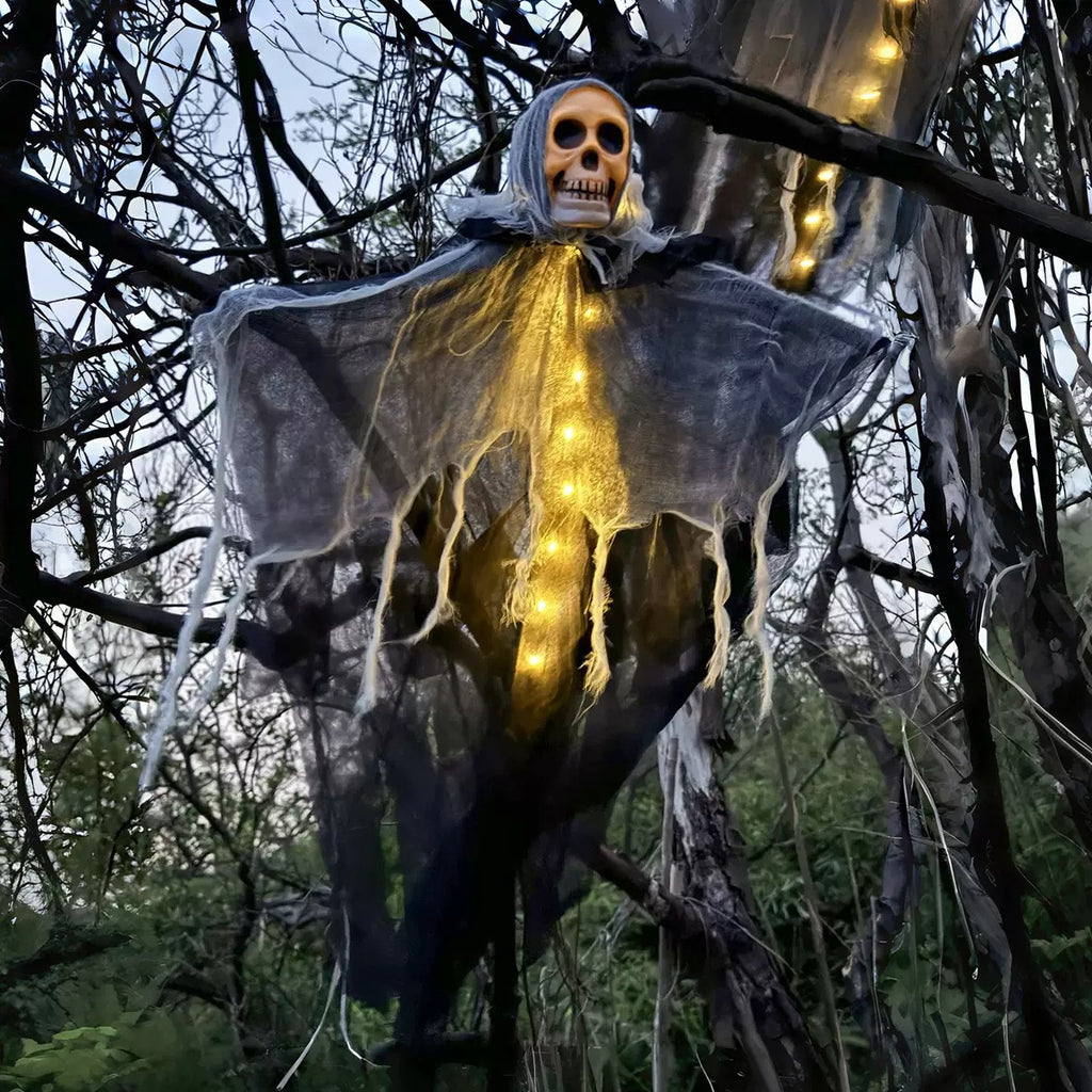 LED hanging ghost Halloween decoration glowing with warm lights in a tree