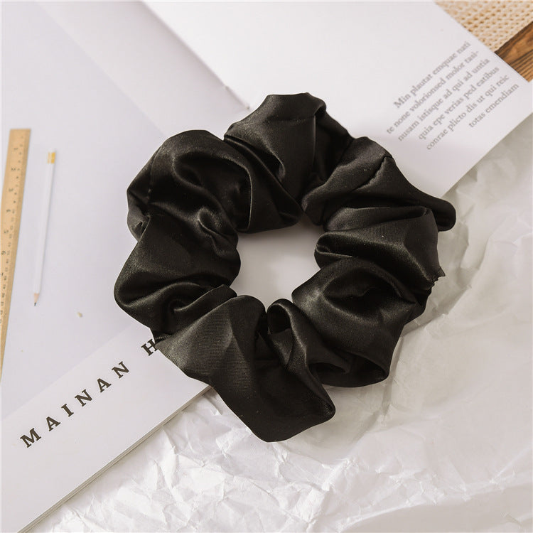 Close-up of one satin scrunchie showing the sheen