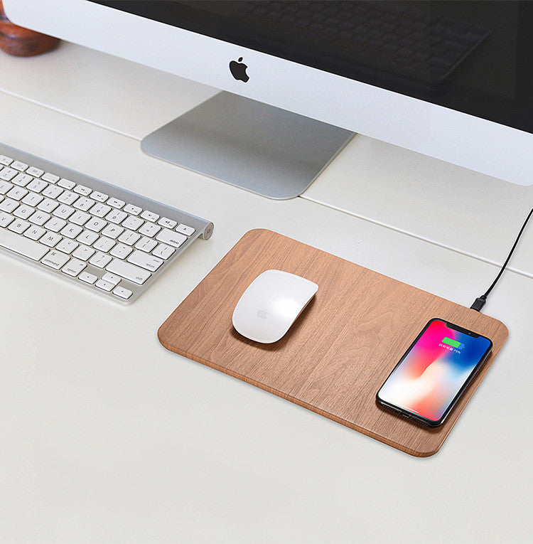 Wireless charging mouse pad in brown wood grain beside a keyboard