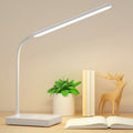 White rechargeable LED desk lamp on a desk with books