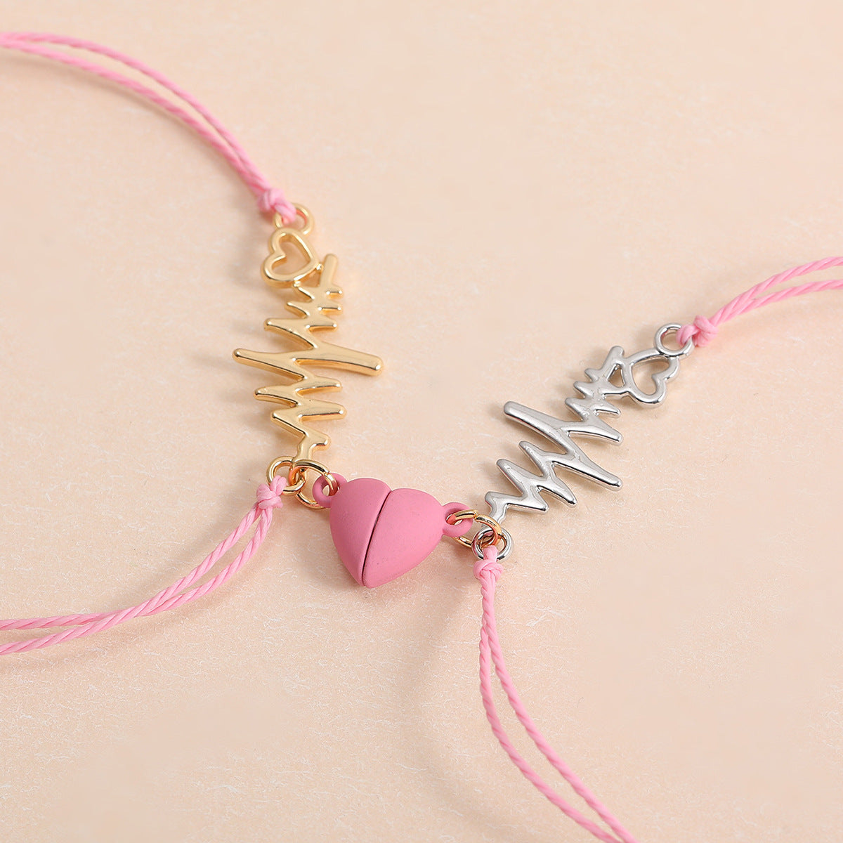 Pair of ECG charm bracelets on red braided rope cords