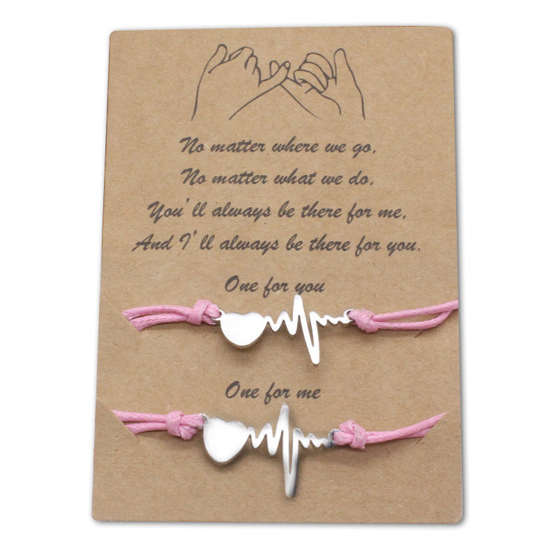 Black and pink rope heartbeat bracelet pair laid flat