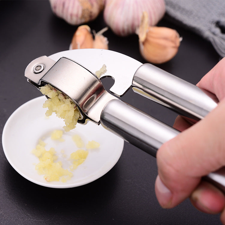 Stainless steel garlic press on a board