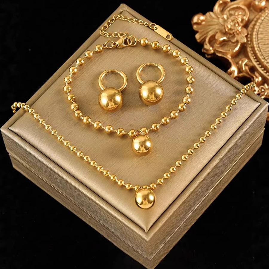 Three-piece gold ball bead set laid together