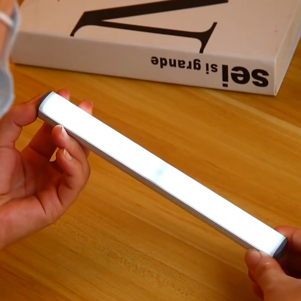 Under-cabinet LED sensor light bar glowing under a kitchen shelf