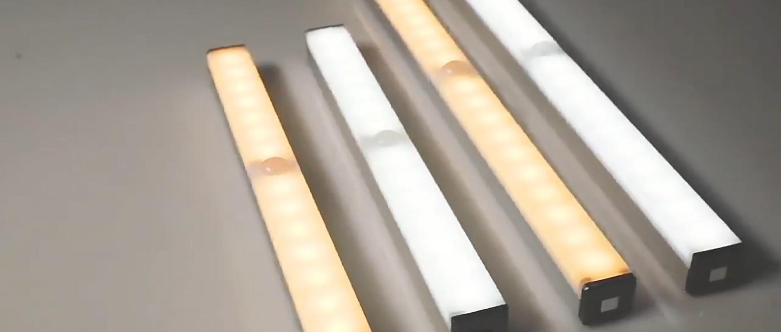 Under-cabinet LED sensor light bar glowing under a kitchen shelf